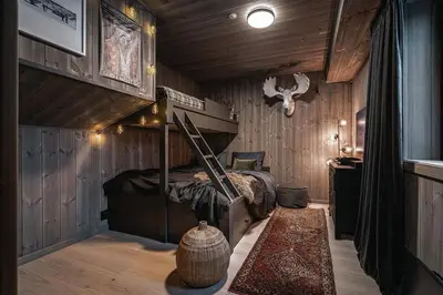 a bedroom with a bed in a room with wooden walls at Two-Storey Penthouse By Hemsedal Ski Resort in Hemsedal