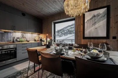 a kitchen with a dining table and a large window at Two-Storey Penthouse By Hemsedal Ski Resort in Hemsedal