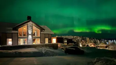 a house with the aurora in the sky at Mountain Cabin With Sauna Atop Fageråsen in Trysil