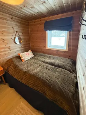 a bed in a log cabin with a window at Mountain Cabin Near Gaustatoppen And Måsafjell in Tuddal