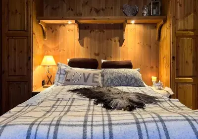 a dog laying on a bed in a bedroom at Mountain Cabin With Cinema Near Synnfjellporten in Nord Torpa