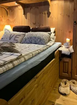 a large bed in a room with wooden walls at Mountain Cabin With Cinema Near Synnfjellporten in Nord Torpa