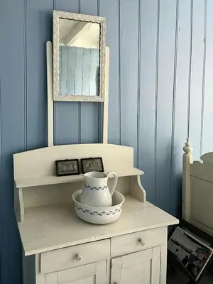 a table with a mirror and a vase on it at Historic Timber House From The 1800S In Nordfjord in Olden