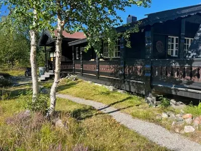an old house with a tree in front of it at Modernised Cabin By The Ski Lift In Hovden in Bykle