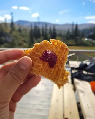 a person holding a piece of food in their hand at Mountain Cabin With Ski Access In Høgevarde in Flå