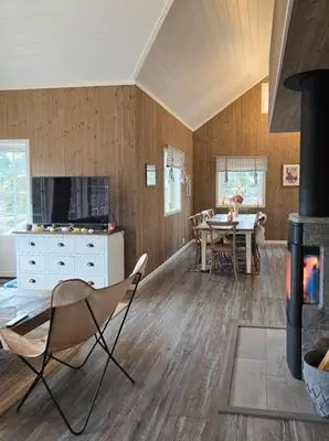 a living room with a fireplace and a table at Mountain Cabin With Ski Access In Høgevarde in Flå