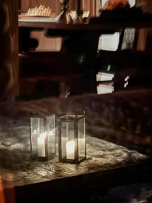 a group of candles in glass containers on a table at Handmade Cabin By Pond On Golsfjellet in Gol