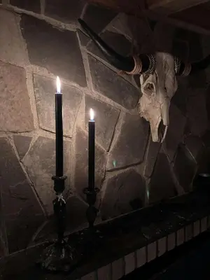 two candles on a stone wall with a skull at Handmade Cabin By Pond On Golsfjellet in Gol