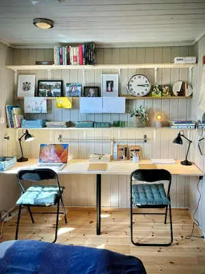 a room with a desk with two chairs and a clock at Unique Cabin And Freestanding Sauna With Views in Aurdal