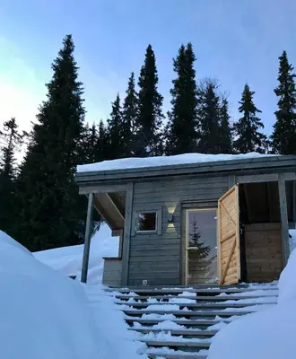 a cabin in the snow with snow covered steps at Unique Cabin And Freestanding Sauna With Views in Aurdal