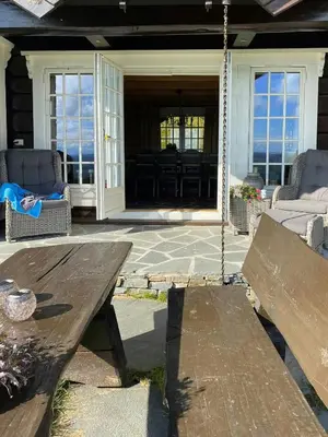 a porch with a wooden bench and a swing at Log Cabin With A View At Golsfjellet in Gol