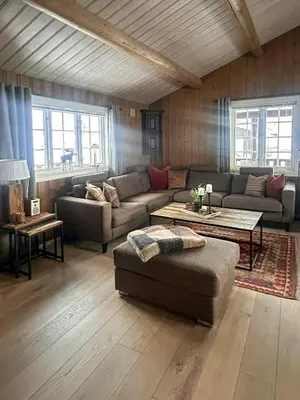 a living room with a couch and a table at Cottage Near Grønnsenknipa With Skiing And Hiking in Ron