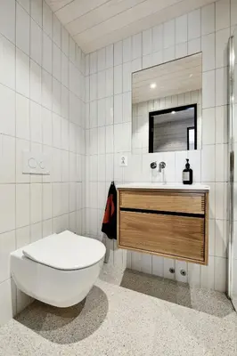 a bathroom with a toilet and a sink and a mirror at Stylish Cabin Near Oppdal Ski Centre in Oppdal
