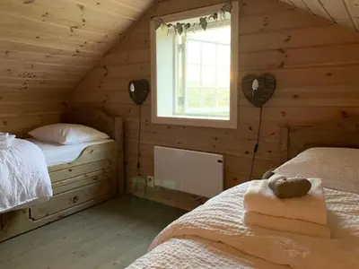 a log cabin bedroom with two beds and a window at Elegant Mountain Cabin With Kjerringafjell View in Brekka
