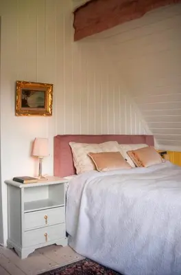 a bedroom with a bed and a table with a lamp at Antique House With Lake View Near Lillehammer in Fryjordet
