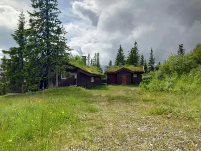 an old house with a grass roof in a field at Log Cabin With Panoramic Views At Skeikampen in Svingvoll