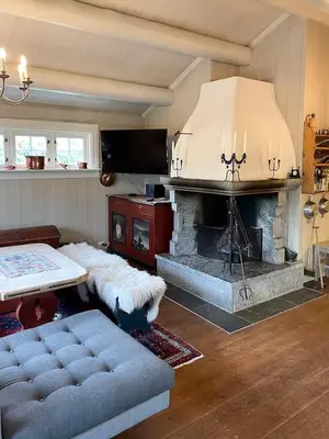 a living room with a fireplace and a couch at Log Cabin With Panoramic Views At Skeikampen in Svingvoll