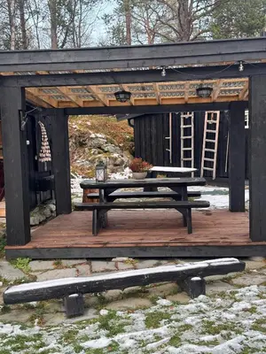 a picnic shelter with a table and a bench at Family-Friendly Cabin With Zipline Near Oppdal in Rennebu