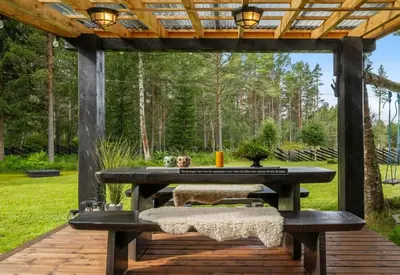 a picnic table with two benches on a wooden deck at Family-Friendly Cabin With Zipline Near Oppdal in Rennebu