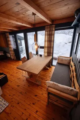 a dining room with a wooden table and a couch at 6 Bed traditional mountain cabin in Geilo - close to skiing and hiking in Hol