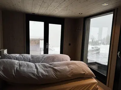 a bedroom with two beds and a large window at Beautiful Ski-in Ski-out Cabin at the top of the mountain in Hafjell in Hafjell