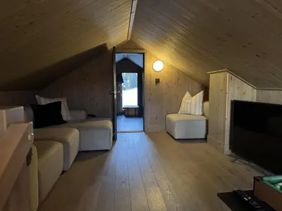 a attic room with two beds and a flat screen tv at Beautiful Ski-in Ski-out Cabin at the top of the mountain in Hafjell in Hafjell