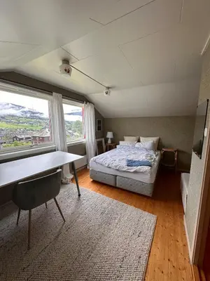 a bedroom with a bed and a desk and a window at Perfect family house in Voss in Vossevangen