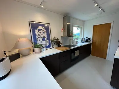 a kitchen with a counter and a table with a lamp at Perfect family house in Voss in Vossevangen