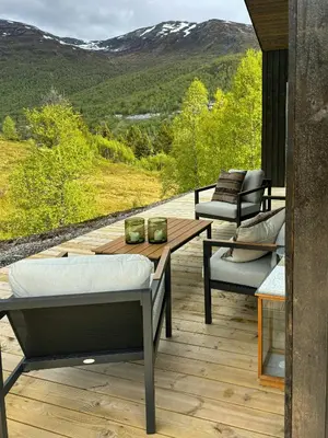 a patio with a table and chairs on a deck at Cabin With Ski-Inski-Out At Stranda Ski Resort in Stranda
