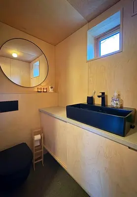 a bathroom with a blue sink and a mirror at Architect-Designed Cabin By Lake With Sauna