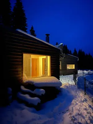 a log cabin in the snow with a window at Architect-Designed Cabin By Lake With Sauna