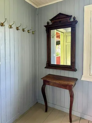 a mirror and a wooden table in a room at Charming Farmhouse From 1919 Near Kristiansund in Kristiansund