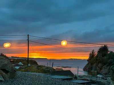 a sunset over a body of water with power lines at Cabin On Hilltop With Beach And Sea Views in Bekkjarvik