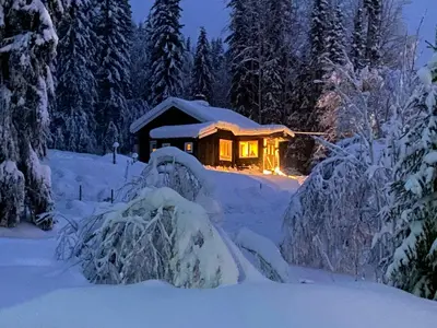 a log cabin in the snow at night at Renovated Cabin On The West Side Of Trysil in Trysil