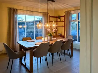a dining room with a wooden table and chairs at Seafront House From 1952 With Views In Veivåg in Bekkjarvik