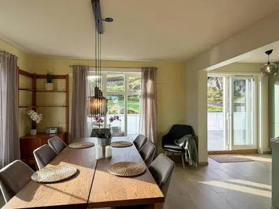 a dining room with a wooden table and chairs at Seafront House From 1952 With Views In Veivåg in Bekkjarvik