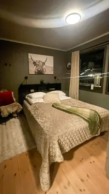 a bedroom with a bed with a deer picture on the wall at Apartment With Ski Inout In Fageråsen Trysil in Trysil