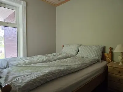 an unmade bed in a bedroom with a window at Fjellro appartment in Os