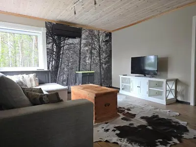 a living room with a couch and a tv at Fjellro appartment in Os