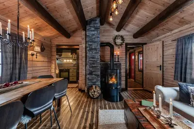 a living room with a fireplace in a log cabin at Charming cabin by Hallingskarvet ski center in Hol