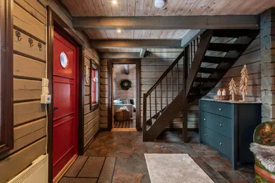 a hallway with a red door and stairs in a house at Charming cabin by Hallingskarvet ski center in Hol
