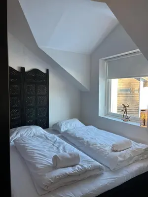 a white bedroom with two beds and a window at Prime Location - Cozy and Big House in Vossevangen