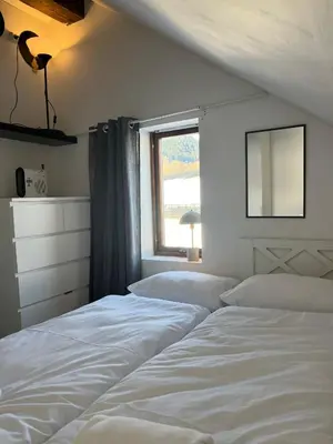 two beds in a bedroom with a window at Prime Location - Cozy and Big House in Vossevangen