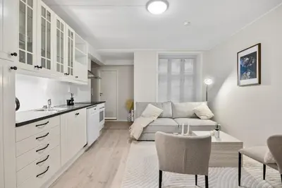 a kitchen and living room with a couch and a table at Central stay apartment - Rosenberg in Bergen
