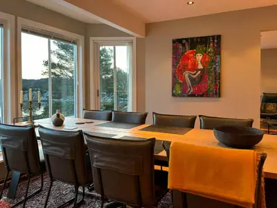 a dining room with a large wooden table and chairs at House With 90 Metres Private Beach On Bømlo in Ervik