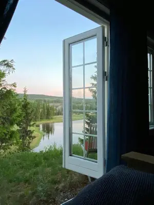 a bedroom window with a view of a river at Family Cabin With Hot Tub At Skeikampen in Svingvoll