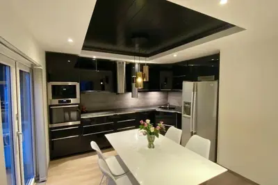 a kitchen with a table with a vase of flowers on it at Trolltunga Fjordview House, Odda in Odda