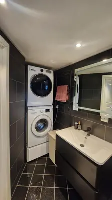 a bathroom with a washing machine and a sink at Fjordclaw SNM- Cozy & Premium Feel in Bergen