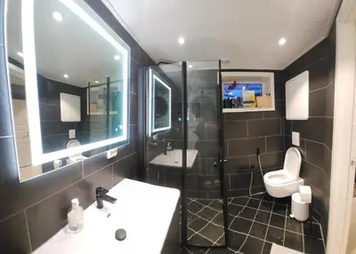 a bathroom with a shower and a sink and a toilet at Fjordclaw SNM- Cozy & Premium Feel in Bergen