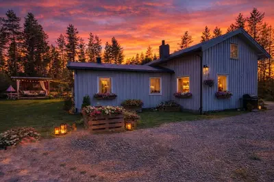a house with lights in front of it at sunset at Grandma Guest House, Rena Near Ski, Biking, River summer camp in Åmot
